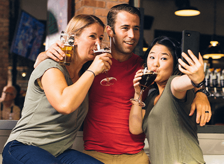 Three friends taking a selfie while drinking beer
