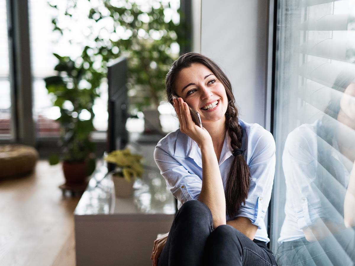 A woman smiling while talking on a smartphone