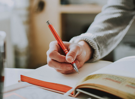 Closeup of someone writing in a notebook