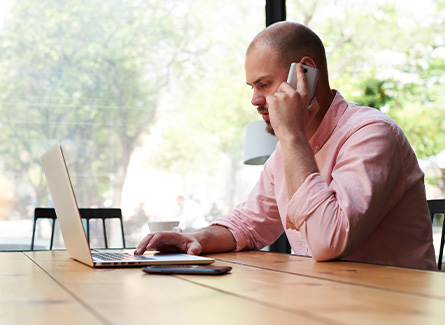Man on the phone while using a laptop