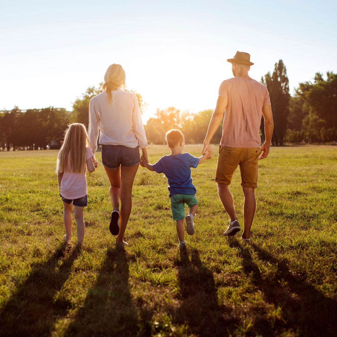 A family with two kids walking together at sunset