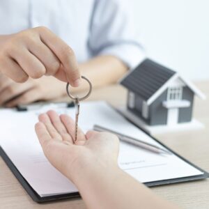 Person handing over a key to someone with their palm out.