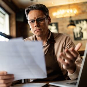 man confused looking at paperwork